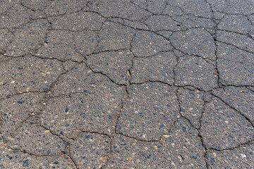 a part of a highway covered with cracked asphalt