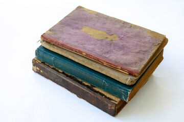 Obraz premium Old damaged books stacked on top of each other. Yellowed natural paper texture. On isolated white background. Clean close-up.