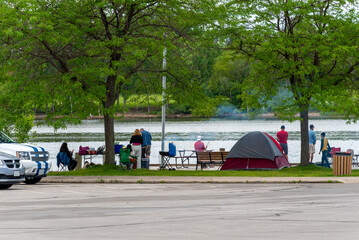 People Fishing And Picnicing At The Dock On Fox River Near De Pere, Wisconsin