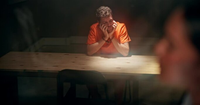 Man, interrogation room and criminal waiting, glass and detective discussion for crime with arrested convict for robbery. Planning, confession strategy and police together, people and prisoner