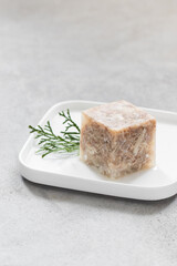 Chicken jelly in the shape of a cube. On a plate. Copy space