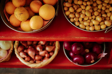 Various fruits and vegetables in baskets on red shelves