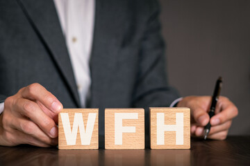 There is wood cube with the word WFH. It is an abbreviation for Work From Home as eye-catching...