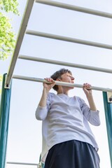 Person Doing Pull-Ups on a Sunny Day at an Outdoor Park