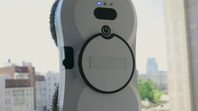 A robotic white Automotive tire is cleaning a glass window