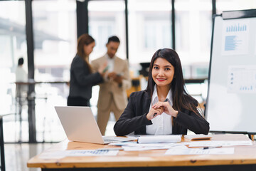 Confident asian businesswoman using laptop in meeting room.