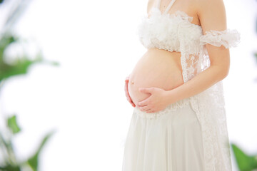 お腹に赤ちゃんのいる女性がお腹を包み込むように手をのせる