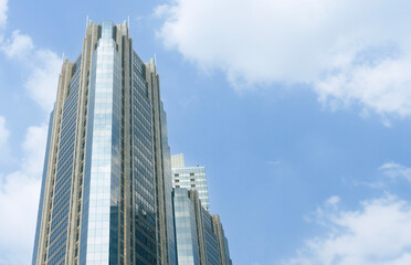 Modern office buildings exterior towering against blue sky. Jakarta Indonesia skyline viewed from below with facade of apartments, condominiums and offices.