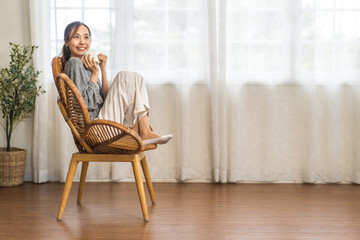 Portrait of smiling happy cheerful beauty pretty asian woman relaxing drinking and looking at cup of hot coffee or tea.Girl felling enjoy having breakfast in holiday morning vacation on bed at home