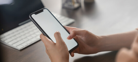 Hand holding smartphone mockup of blank screen for graphic display montage.