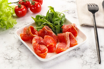 Sliced salmon with fresh arugula