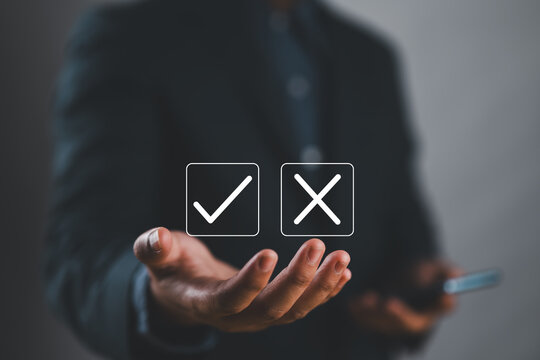 Businessman showing check right and wrong choice The idea is to decide to vote. Think yes or no decisions, and business options for difficult situations in dilemma. true and false symbols agreeing