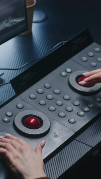 Female editor uses digital color grading control panel. Colorist makes video or photo color correction on computer in studio. Footage and program interface with RGB color wheels and levels on monitor.