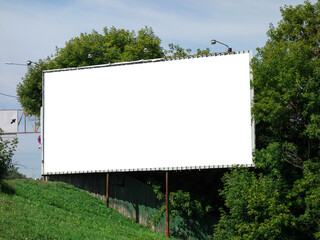 Billboard on a background of green trees