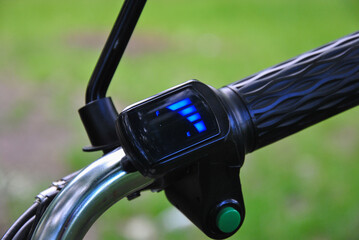 close-up of the battery charge level indicator display on the handlebar of an electric bicycle. blurred background