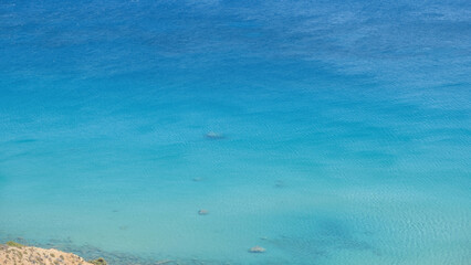 Ripple sea water, above view of sandy bottom with few pebble background, copy space. Greece nature