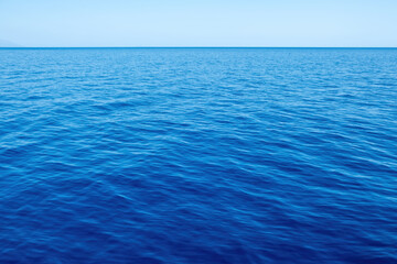 Ripple sea joins with blue sky background texture. Empty clear sea water surface. Copy space