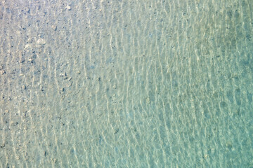 Greece, transparent sea water with sandy bottom, aerial drone view, summer holiday destination.