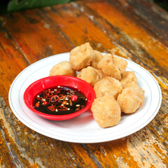 Fried tofu is a popular snack served on a plate complete with soy sauce