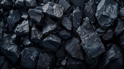 Close-up of dark, rough, textured rocks in a natural, rugged setting. Ideal for geology, nature, and mineral resources themes.