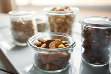 Bowls, nuts and seeds on plate, kitchen and hazelnut for nutrition, health and table with diet for...