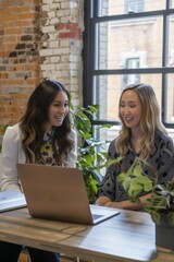 Two women discussing work at a desk