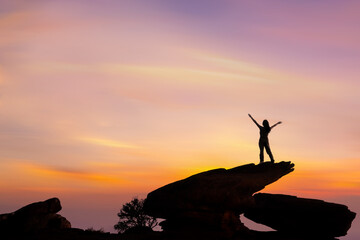 Female  hiker enjoying the beautiful sunset from mountain top.