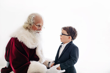 Obraz premium Santa talking to boy in suit with white background, close-up
