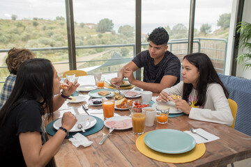 Latin family enjoying breakfast during his holidays