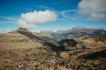 Swiss mountain peaks in Lenk under a bright blue sky with clouds