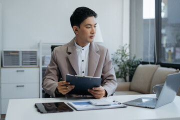 Business man working at office with laptop and documents on desk, financial adviser analyzing data.