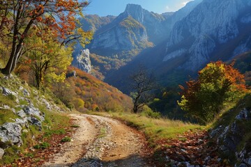 A majestic autumn scene with a dirt road leading through a valley surrounded by mountains with colorful trees