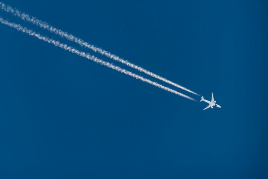 airplane in the blue sky with contrail