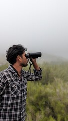 Obraz premium man looking through binoculars