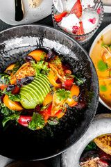 Colorful salad bowl with fresh greens, ripe avocado, juicy tomatoes, and grilled chicken, garnished with herbs. A healthy meal option
