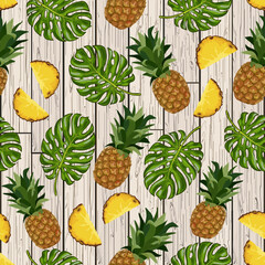 Whole and chopped pineapples.Palm leaves and pineapples on a wooden background in a seamless vector pattern.