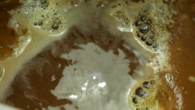 Beer wort boiling while brewing homemade beer close-up