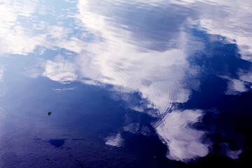Sky and clouds reflected on the water surface