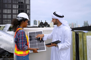 Middle eastern man and African woman are working together on rooftop.