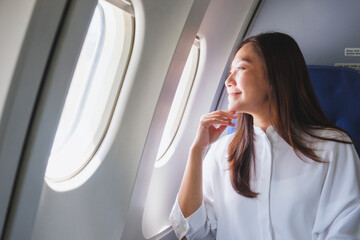 Portrait image of a woman looking through an airplane window