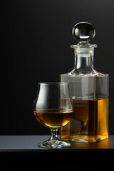 Old decanter and glass with whiskey, cognac or brandy.