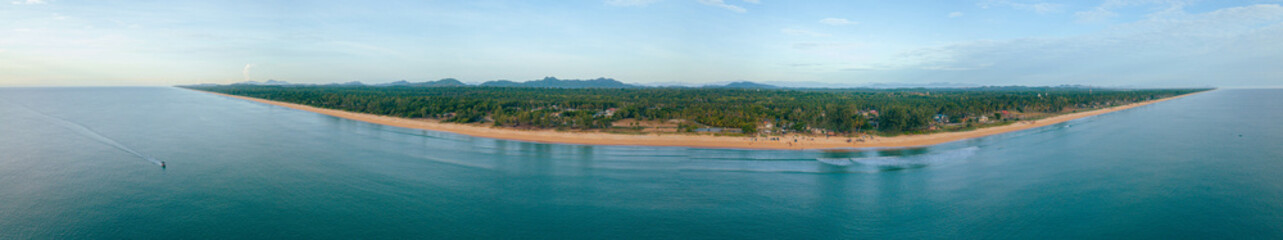 Panoraman aerial drone view of shoreline scenery with blue sea water at Pantai Jambu Bongkok, Marang, Terengganu, Malaysia