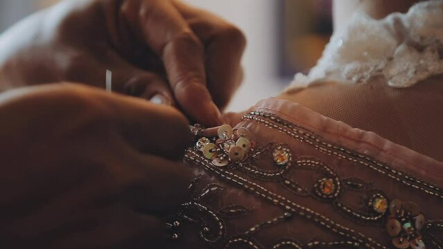 A skilled dressmaker fitting a dress on a mannequin, exhibiting utmost care and detail.