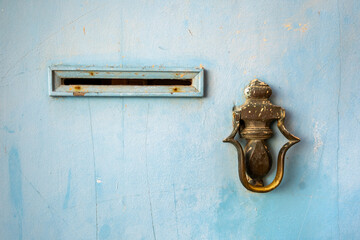 Detail of a typical Moroccan metal door. You can see a bronze knocker and a slot for depositing...