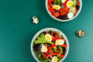 Salad with quail egg, tomato and lettuce.