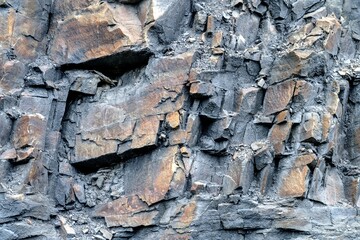 Natural mine stone wall with different stone shapes and colors and an uneven pattern