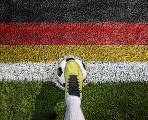 Shot of a soccer player standing on the field with germany flag background.