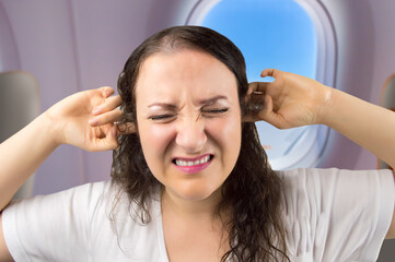 Woman having ear pop on the airplane while taking off.