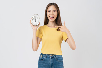 Young asian woman holding alarm clock and smiling isolated on white background studio.
