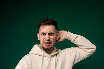 Man in White Hoodie Holding Hands to Ears